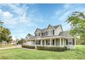 A two-story light green house with a large front yard and walkway at 7055 Big Bend Dr, Saint Cloud, FL 34771