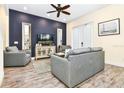 Bright living room with gray sofas, a large TV, and French doors at 2984 Salted Rim Rd, Kissimmee, FL 34747