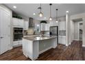 Modern kitchen with white cabinets, granite island, and stainless steel appliances at 30215 Bretton Loop, Mount Dora, FL 32757