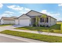 Two-car garage, light grey exterior, and a partially visible neighboring house at 2012 Rosewood Dr, Bartow, FL 33830