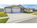 Two-car garage and a large driveway, light grey exterior at 2012 Rosewood Dr, Bartow, FL 33830