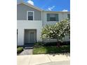 Two-story townhome with gray siding, green shutters, and landscaping at 8940 Sydney Ave, Kissimmee, FL 34747