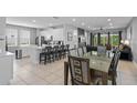 Open kitchen with island, white cabinets, and dining area at 7481 Marker Ave, Kissimmee, FL 34747