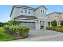 Two-story home with gray siding, two-car garage, and landscaping at 7481 Marker Ave, Kissimmee, FL 34747