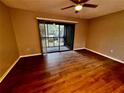 Bright bedroom with wood-look floors and sliding glass doors to balcony at 180 Waterfall Way # 203, Altamonte Springs, FL 32714