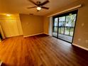 Bright living room with wood-look floors and sliding glass doors leading to a balcony at 180 Waterfall Way # 203, Altamonte Springs, FL 32714