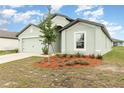 Charming light green house with a two-car garage and landscaping at 1317 Brenway Dr, Mascotte, FL 34753