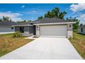 Modern two-car garage home with stone accents at 43 S Kentucky Ave, Umatilla, FL 32784