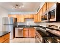 Modern kitchen with stainless steel appliances and wood cabinets at 320 Black Oak Ct # 107, Altamonte Springs, FL 32701