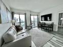 Bright living room featuring a comfortable sofa and dining area at 6165 Carrier Dr # 3802, Orlando, FL 32819