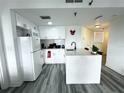 White kitchen with an island, stainless steel appliances, and subway tile backsplash at 6165 Carrier Dr # 3802, Orlando, FL 32819