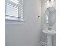 Small powder room with pedestal sink and octagon mirror at 7424 Bent Tree Loop, St Cloud, FL 34771