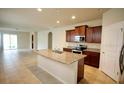 Open kitchen with island and stainless steel appliances at 16253 Pebble Bluff Loop, Winter Garden, FL 34787