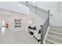 Bright and airy entryway with modern staircase and light wood floors at 7540 Estuary Lake Loop, Celebration, FL 34747