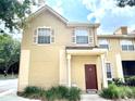 Tan townhome with a brown door and shutters at 837 Grand Regency Pt # 207, Altamonte Springs, FL 32714