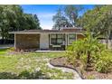 Single-story home with stone facade, landscaping, and a palm tree at 424 E Welch Rd, Apopka, FL 32712