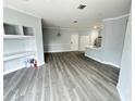Open living room with gray vinyl flooring and built-in shelving at 3561 Conroy Rd # 227, Orlando, FL 32839