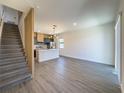 Open concept living room with modern kitchen, island, and staircase at 3229 Energy Dr, Kissimmee, FL 34747