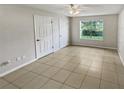 Spacious bedroom with tile flooring, double closets and a window at 5545 Devonbriar Way # I101, Orlando, FL 32822