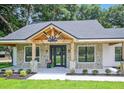 Charming farmhouse front porch with stone pillars and wooden beams at 19906 Eldorado Dr, Eustis, FL 32736