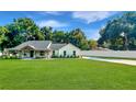 Landscaped lawn with a spacious driveway leading to a charming farmhouse at 19906 Eldorado Dr, Eustis, FL 32736