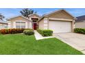 Tan one-story house with red door and two-car garage at 1219 Snug Harbor Dr, Casselberry, FL 32707