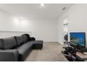 Spacious bonus room with black leather sectional sofa and TV at 3387 Beaute Dr, Kissimmee, FL 34746