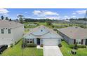 Two-story house with a light blue exterior, two-car garage, and a nicely landscaped yard at 544 Talisi Loop, Saint Cloud, FL 34771