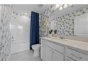 Bathroom with white subway tile and patterned wallpaper at 2912 Oakmere Ave, Davenport, FL 33837