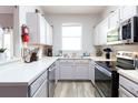 L-shaped kitchen with stainless steel appliances and light cabinets at 244 Capri Dr, Davenport, FL 33897