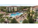 Resort-style pool and hot tub with plenty of lounge chairs and landscaping at 8801 Worldquest Blvd # 4406, Orlando, FL 32821