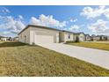 Landscaped front yard with driveway leading to a two car garage at 1728 Forest Run Ln, Auburndale, FL 33823