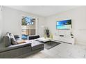 Living room with gray sectional sofa, white tile floors, and sliding glass doors leading to the pool at 1552 Plunker Dr, Davenport, FL 33896