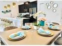 Dining area with table set for six, adjacent to kitchen at 962 Splash Shot Pl, Davenport, FL 33896