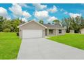 Newly built single-story house with a white garage door at 297 Malauka Run, Ocklawaha, FL 32179