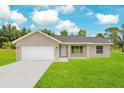 Newly constructed home with a white garage door and spacious lawn at 297 Malauka Run, Ocklawaha, FL 32179