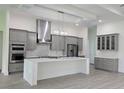 Modern kitchen with gray cabinets, white countertops, and stainless steel appliances at 555 Sanctuary Golf Pl, Apopka, FL 32712