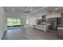 Open floor plan kitchen with island, stainless steel appliances, and gray cabinets at 555 Sanctuary Golf Pl, Apopka, FL 32712