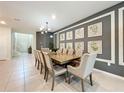 Formal dining room with a large table, eight beige chairs, and framed wall art at 2060 Lelani Cir, Davenport, FL 33897