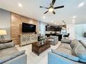 Open living area featuring gray sofas, a wood coffee table, and a large TV at 2060 Lelani Cir, Davenport, FL 33897