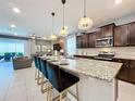 Spacious kitchen with granite countertops, dark wood cabinets, and stainless steel appliances at 2060 Lelani Cir, Davenport, FL 33897