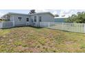 Backyard of a manufactured home with a white vinyl fence and a grassy area at 550 Saint Johns Rd, Tavares, FL 32778