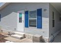 Exterior view of a light gray manufactured home with blue shutters and a small front yard at 550 Saint Johns Rd, Tavares, FL 32778