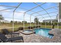 Screened-in pool and spa with lounge chairs at 8903 Stinger Dr, Davenport, FL 33896