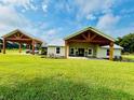 Single-story home with covered porches, attached carport, and expansive lawn at 13715 Se 36Th St, Webster, FL 33597