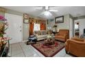 Living room with tiled floors, beige couch, and two armchairs at 1759 Tallo Way, Orlando, FL 32818