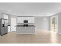 Open kitchen with white cabinets, island, and stainless steel appliances at 531 Tortugas St, Haines City, FL 33844