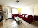 Living room with red sectional sofa and glass coffee table at 695 Florida Pkwy Pkwy, Kissimmee, FL 34743