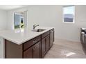 Kitchen island with white countertop and dark brown cabinets, overlooking the backyard at 27512 Stellar Sea Way, Howey In The Hills, FL 34737