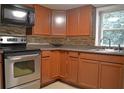 Updated kitchen with wood cabinets, stainless steel appliances, and tile backsplash at 647 S Delaware Ave, Deland, FL 32720